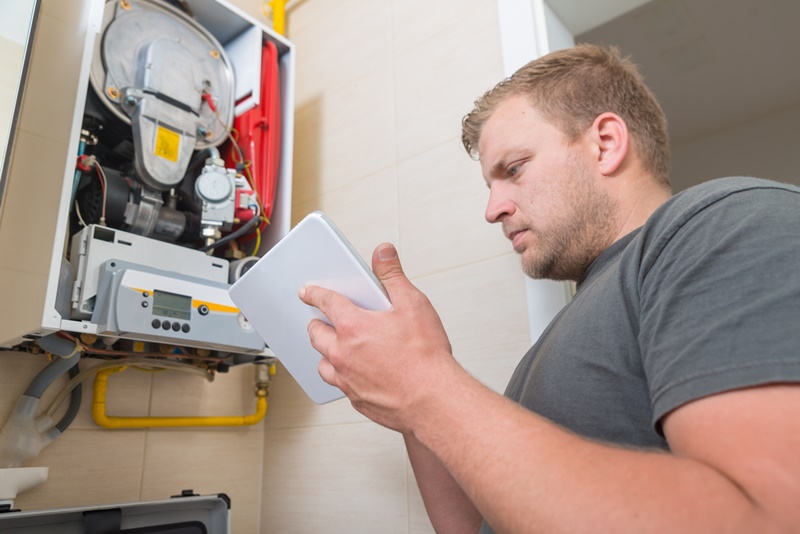 Technician repairing Gas Furnace using field workforce management