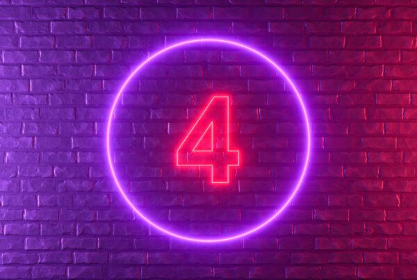 What is a 4 on 4 off shift pattern hero - a pink and purple neon sign depicting a number 4 mounted on an exposed brick wall.