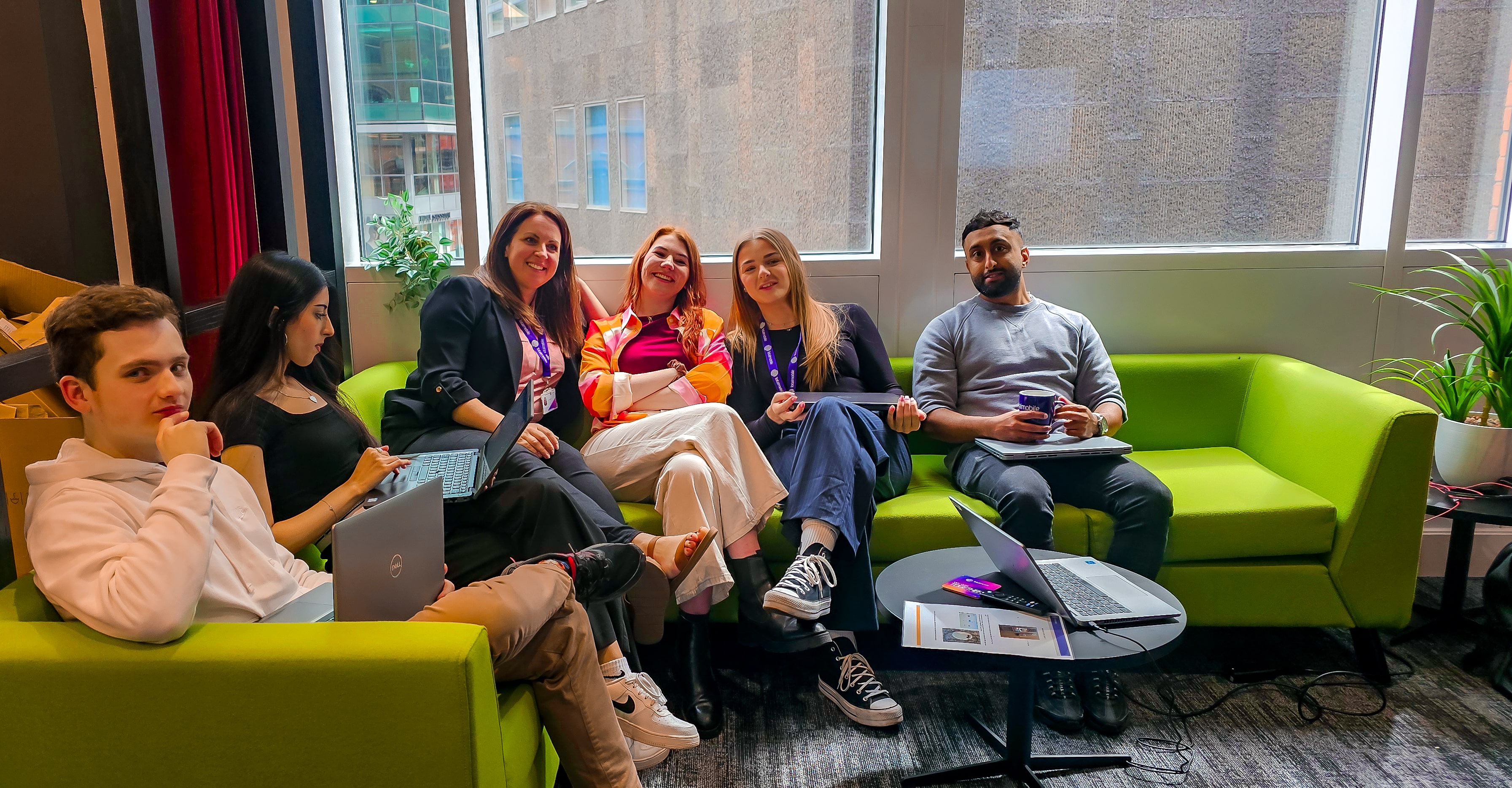 Totalmobile's Manchester team, showing group of mixed young professionals in bright office environment.